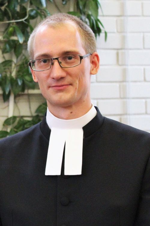 Ähtärin kirkkoherra Kalle Peltokangas papin juhlapuvussa, kaftaanissa seurakuntakeskuksessa.